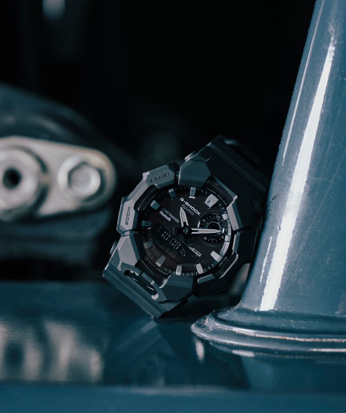 Black wristwatch with a unique design on a reflective surface