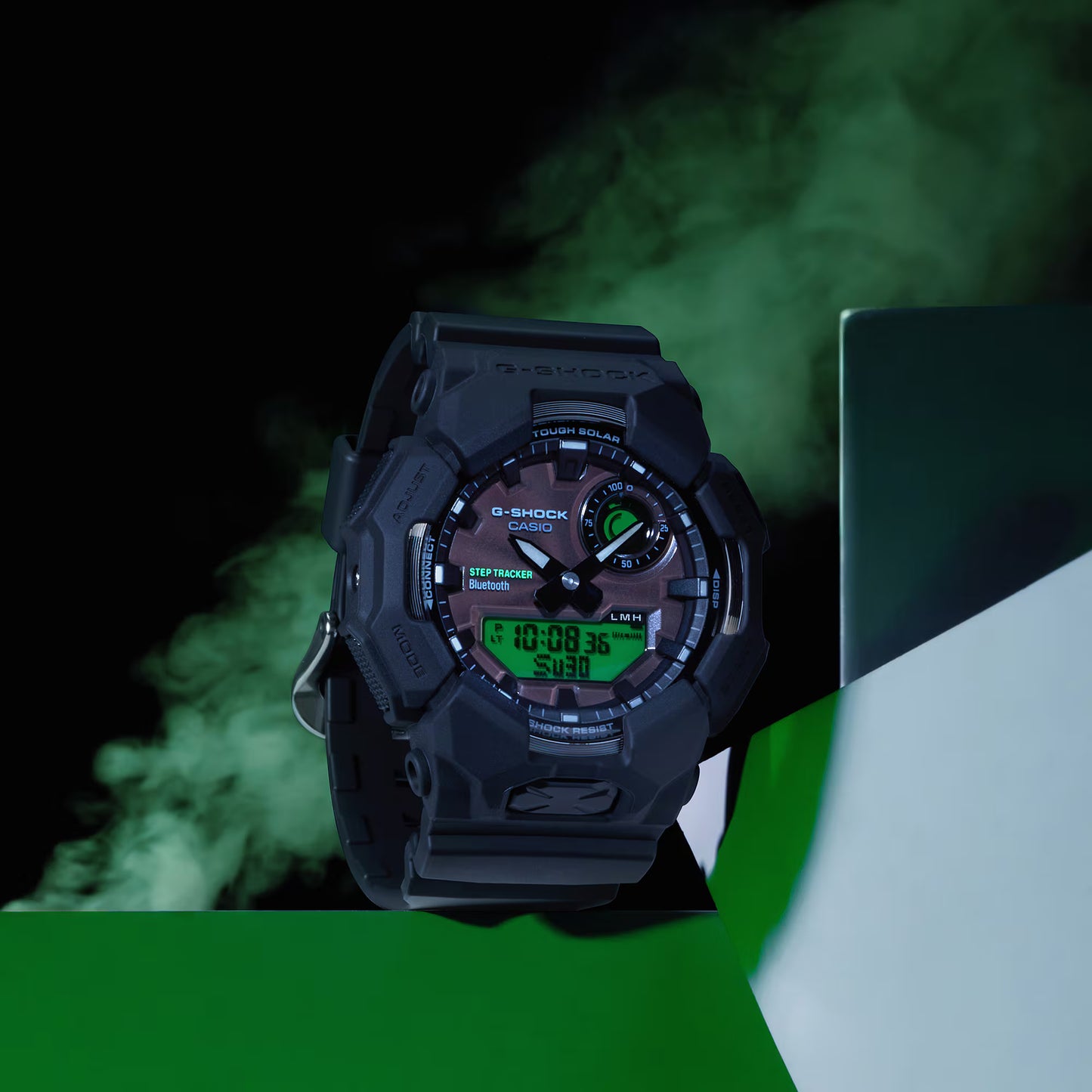 Black Casio G-Shock watch with digital and analog display on a green and white background
