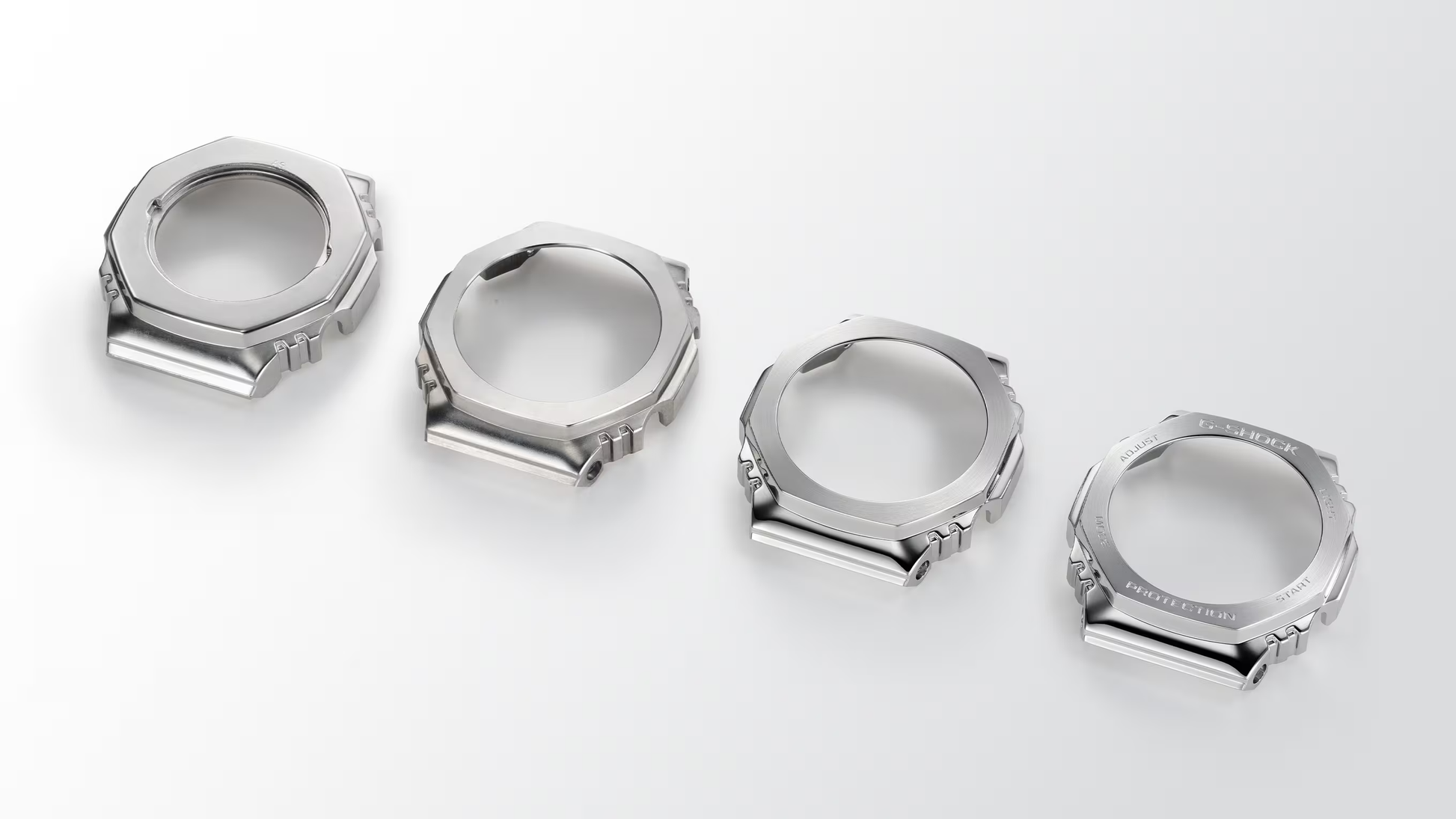 Four metallic watch cases on a white background