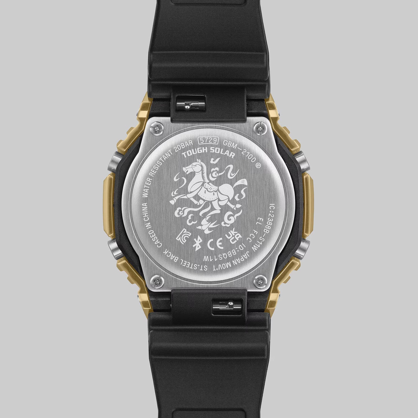 Back view of a watch with engraved design on a gray background