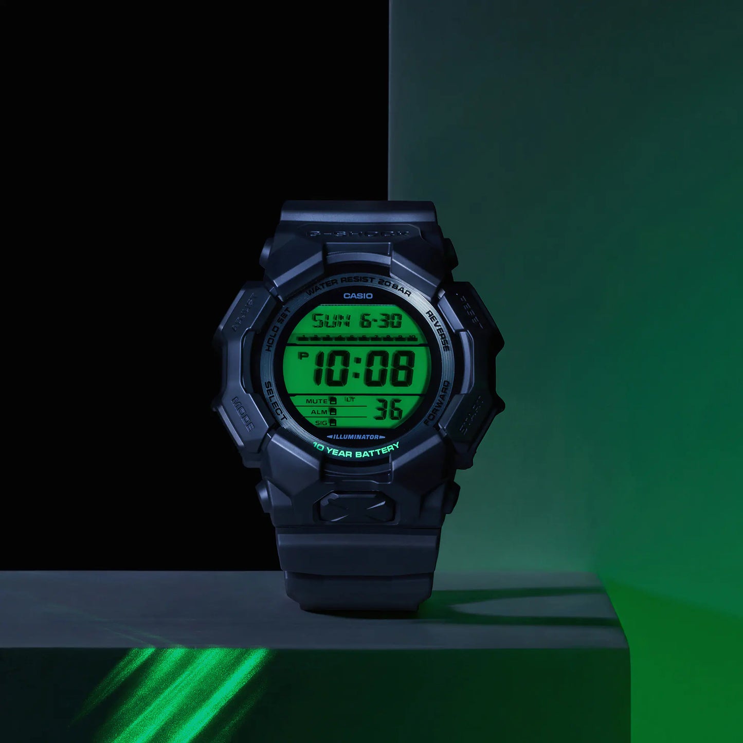 Digital watch with green display on a dark background