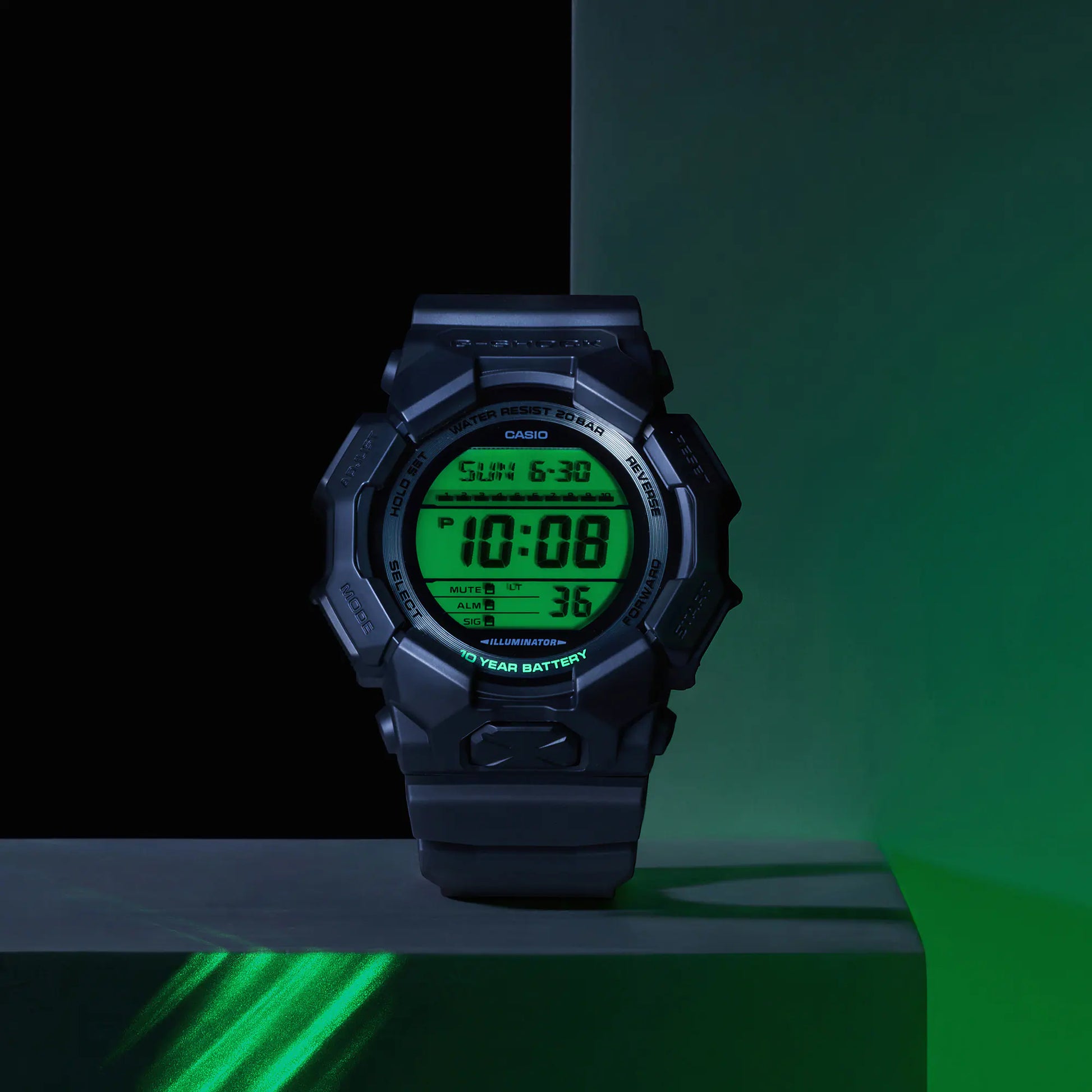 Digital watch with green display on a dark background