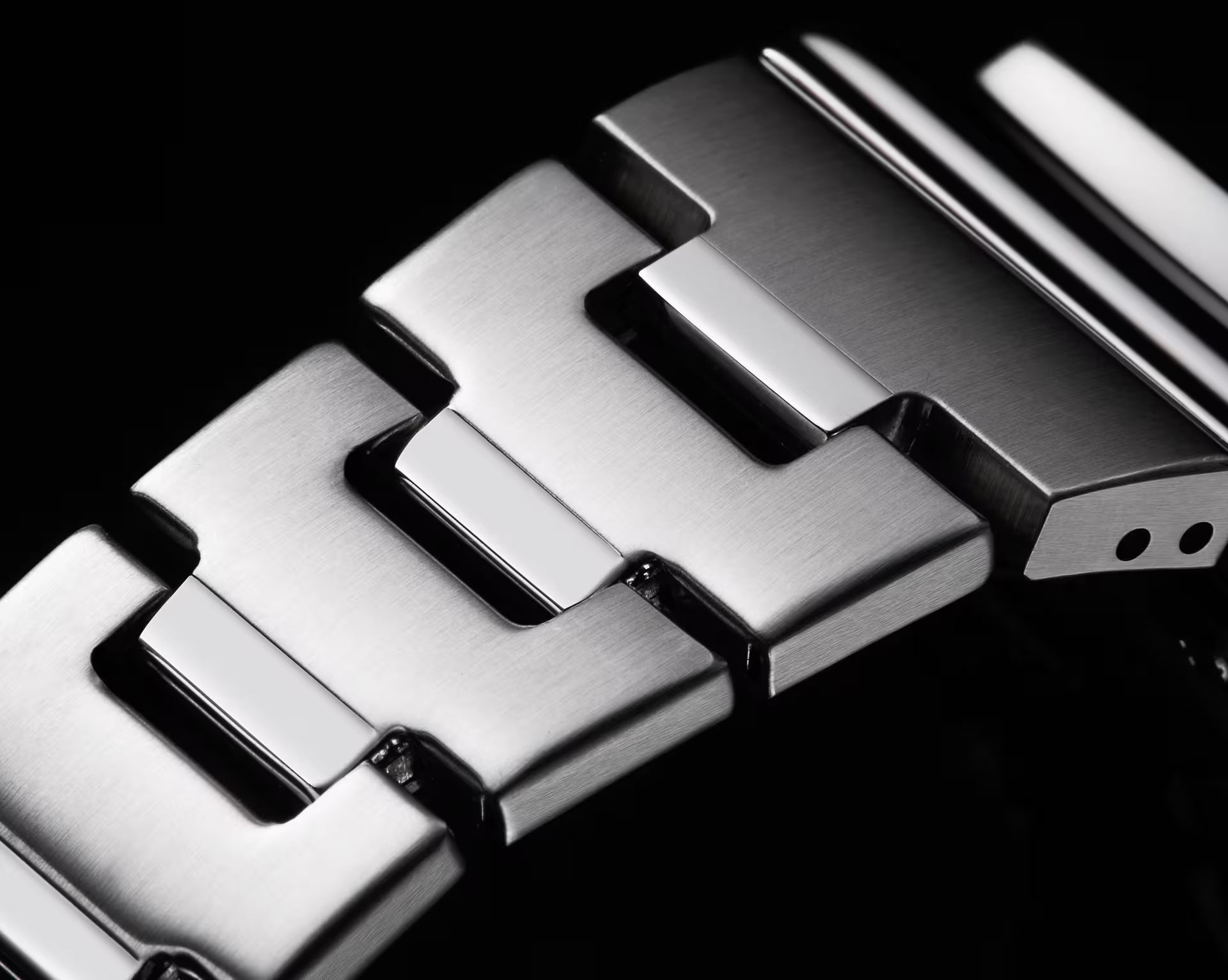 Close-up of a metallic watch strap with a black background