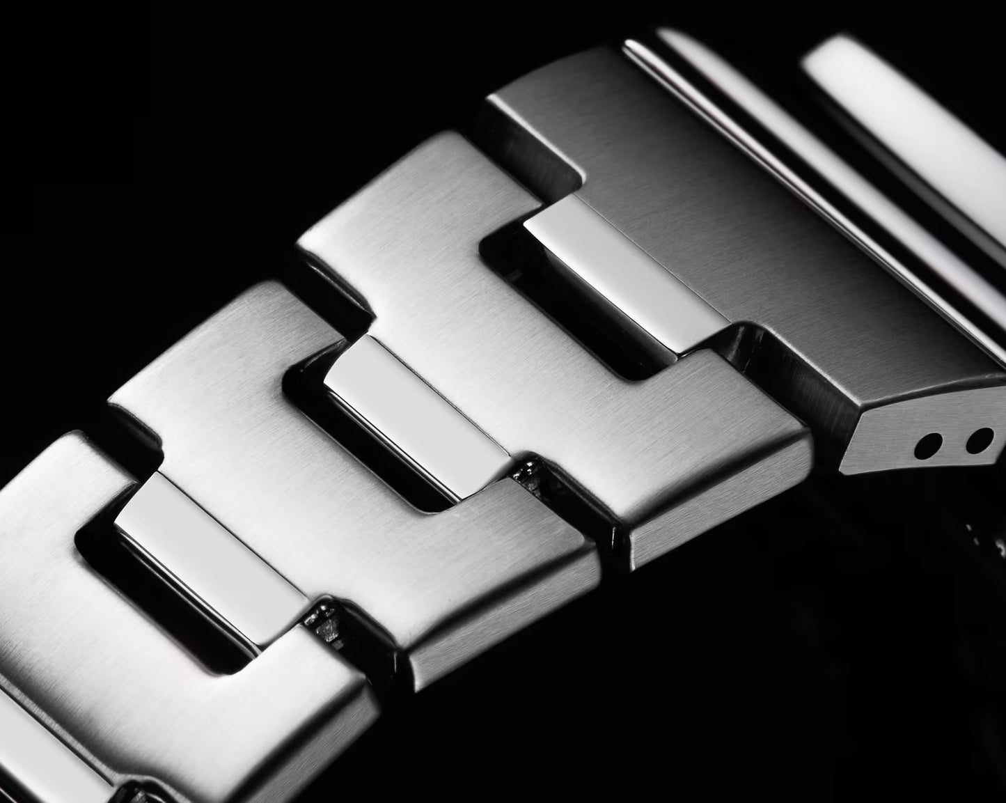 Close-up of a metallic watch strap with a black background