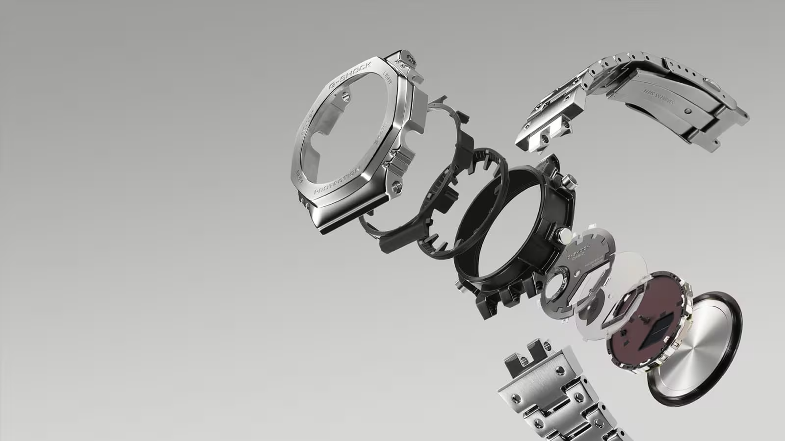 Watch parts including a case and strap on a gray background
