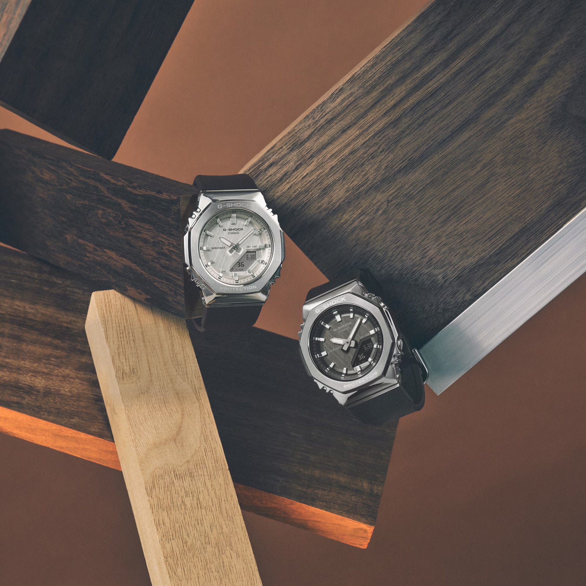 Two watches on a wooden surface with geometric shapes