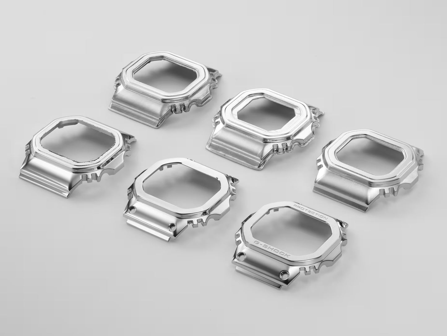 Set of silver metallic watch cases on a light gray background