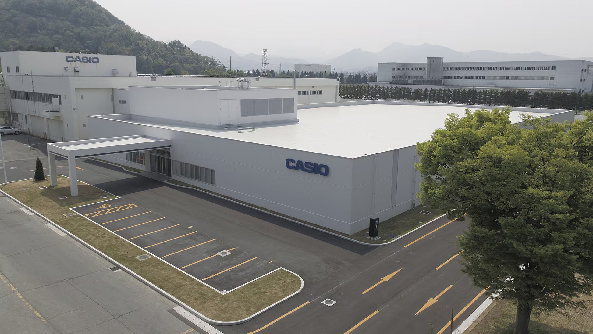 Casio building with parking lot and mountains in the background