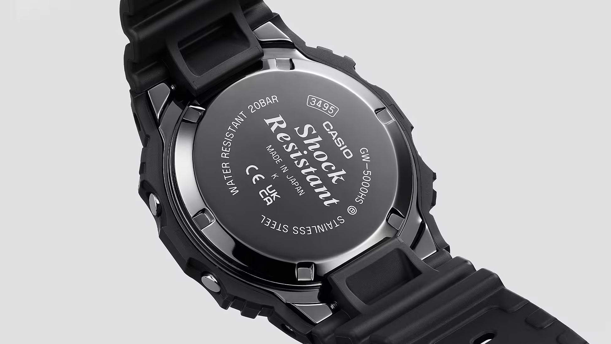 Back view of a Casio G-Shock watch with branding and certification details on a gray background