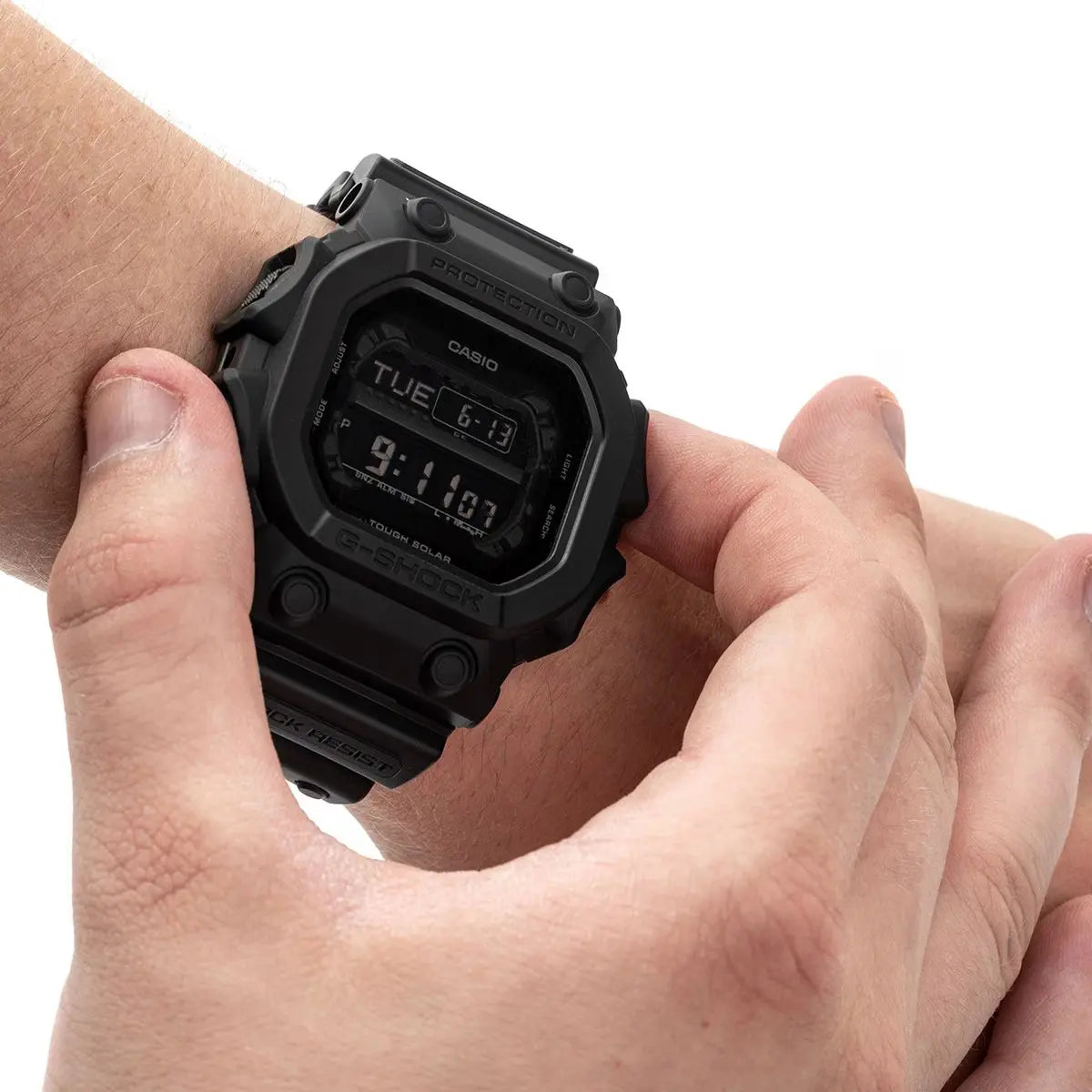 Black Casio digital watch on a wrist with a white background