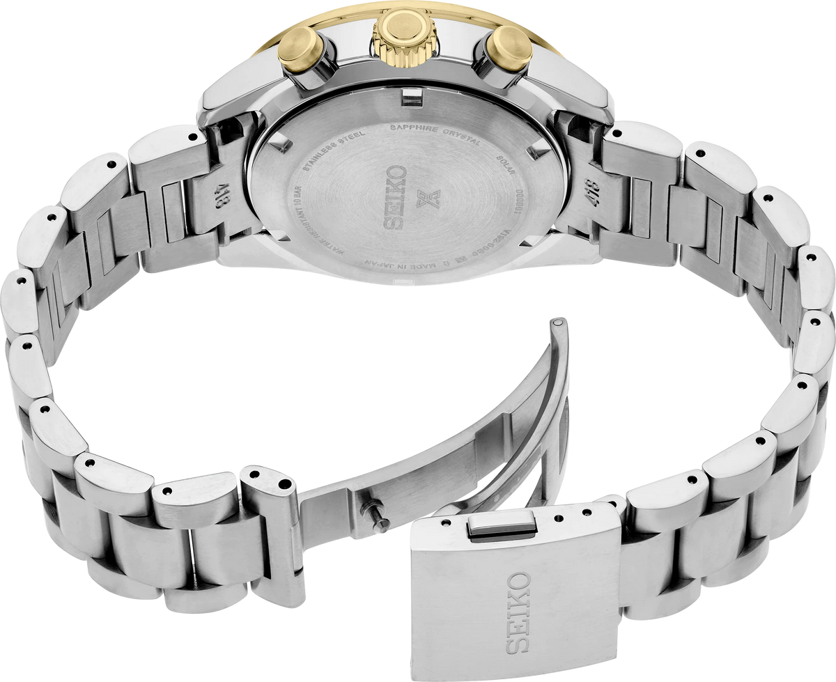 Rear view of a Seiko stainless steel watch with a gold crown, showing the branded metal case back and link bracelet on a white background.