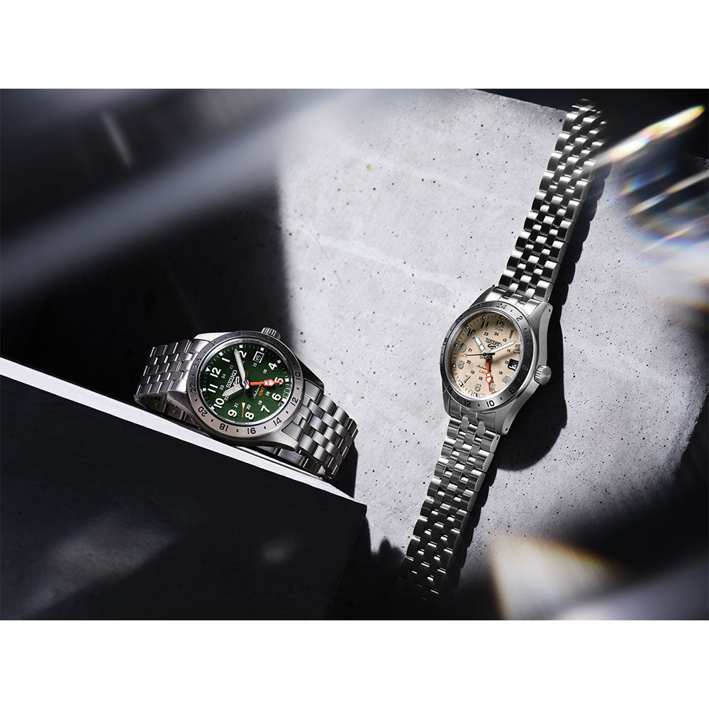 Two watches on a textured surface with a blurred background