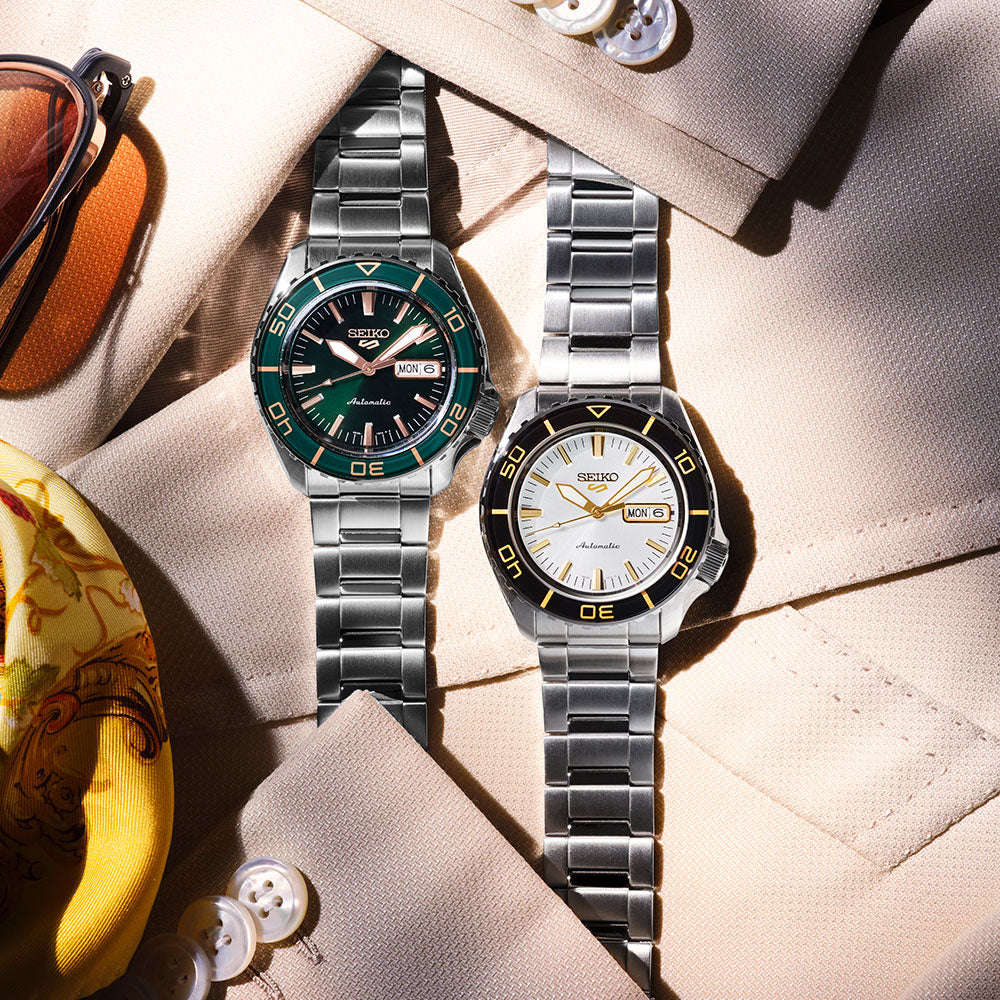 SEIKO 5 Sports HDB004 white dial automatic watch displayed beside a green dial Seiko 5 Sports model on a styled fashion flat lay.