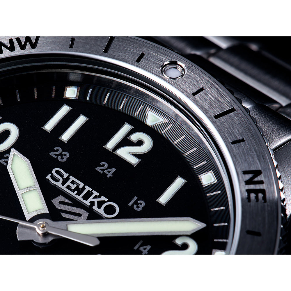 Close-up of a Seiko watch with a black dial and metallic case.