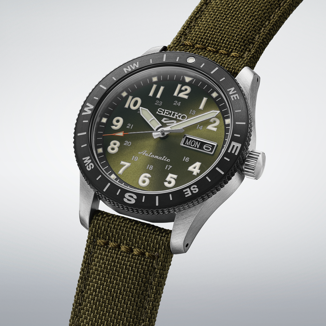 Seiko watch with green strap and green dial on a light gray background