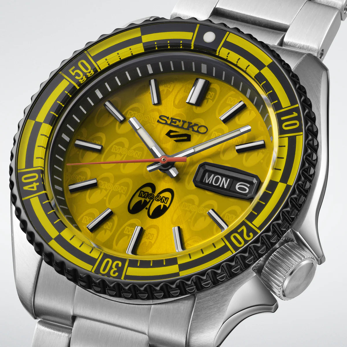 Seiko watch with yellow dial and silver case on a light gray background