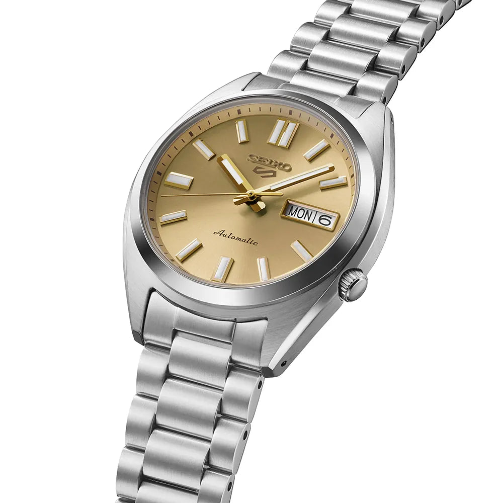 Seiko watch with gold face and silver metal strap on a white background