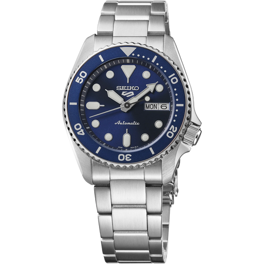 Seiko 5 Sports SRPL77 SKX Mid-Size automatic watch with 38 mm stainless steel case, navy blue dial, luminous hands and markers, blue unidirectional rotating bezel, Hardlex crystal, stainless steel three-row bracelet with tri-fold clasp, screwdown see-through caseback, and Caliber 4R36 automatic movement with 24 jewels, 41-hour power reserve, and day/date display. Water resistant to 100 meters.