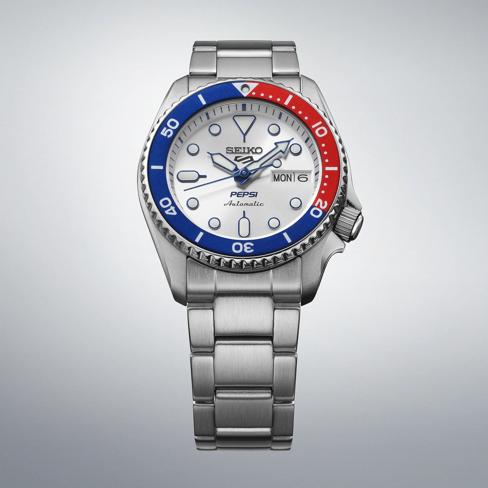 Seiko watch with a red and blue bezel on a gray background
