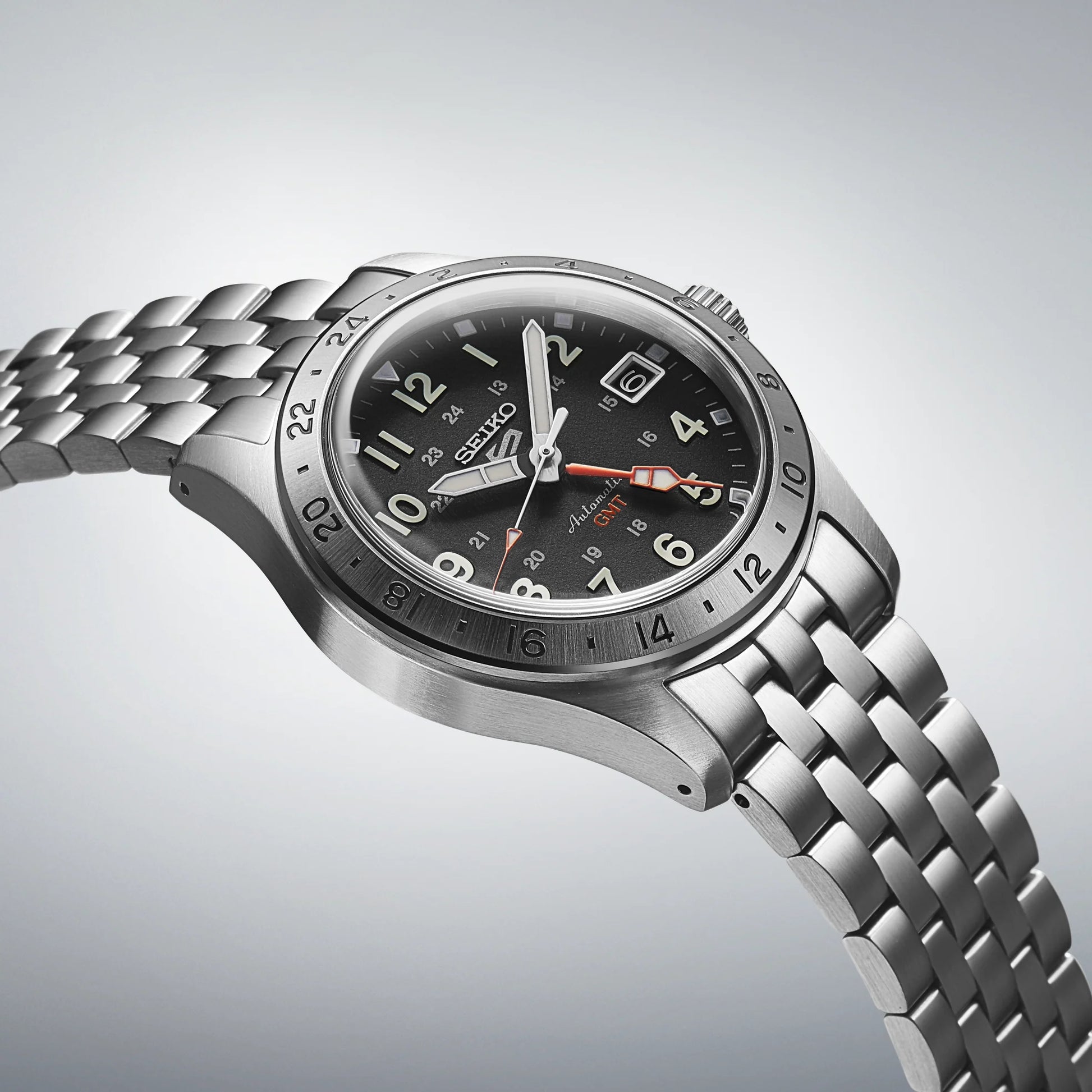 Silver Seiko watch with a black dial on a light gray background