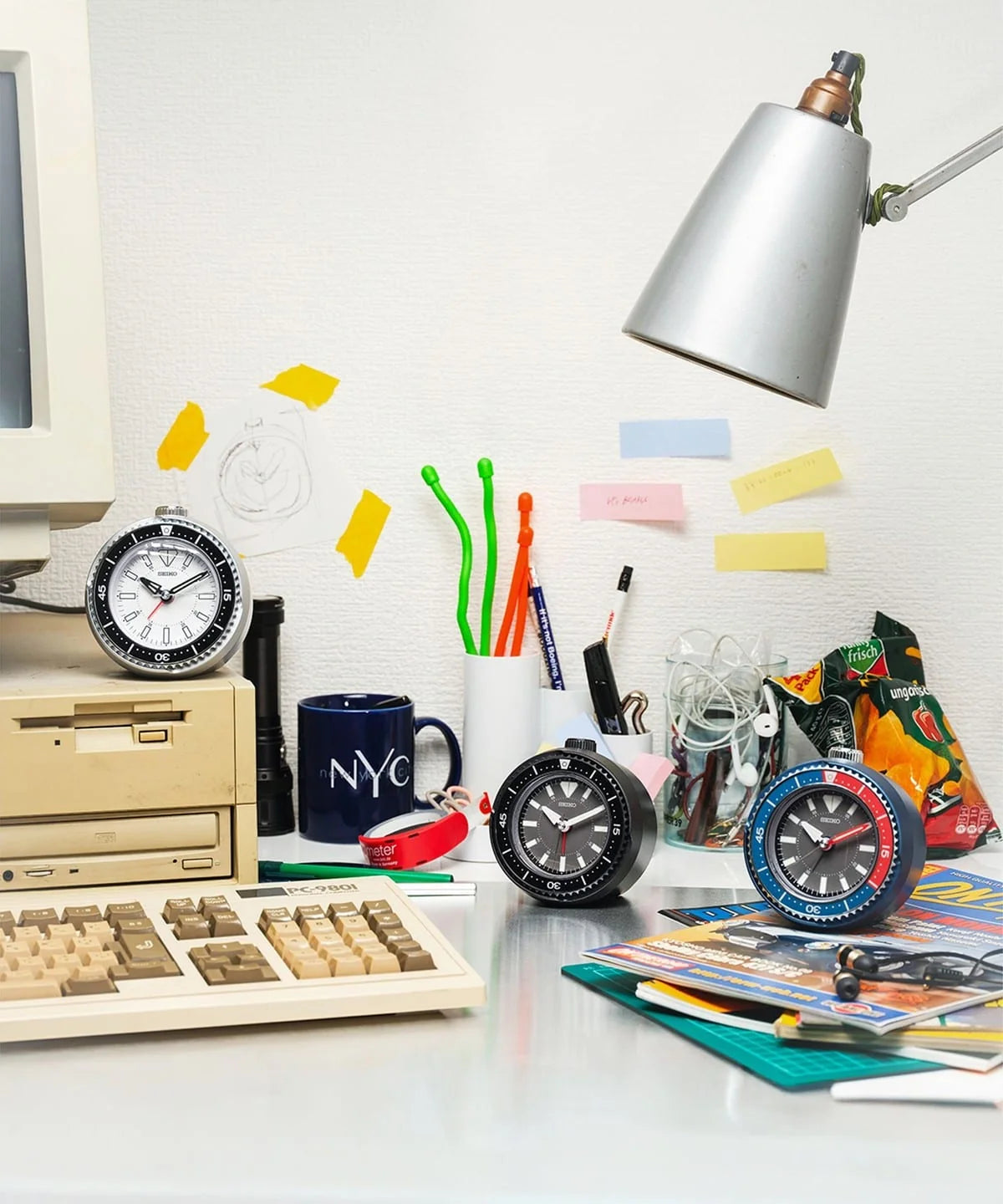 SEIKO Heritage Design rotating bezel alarm clock collection featuring sporty watch-inspired desk clocks in black, green, orange, white, and blue styles.