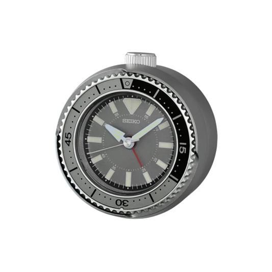 SEIKO QHE207NLH rotating bezel alarm clock with silver-tone metallic case, dark gray diver-style dial, LumiBrite markers, and watch-inspired design.