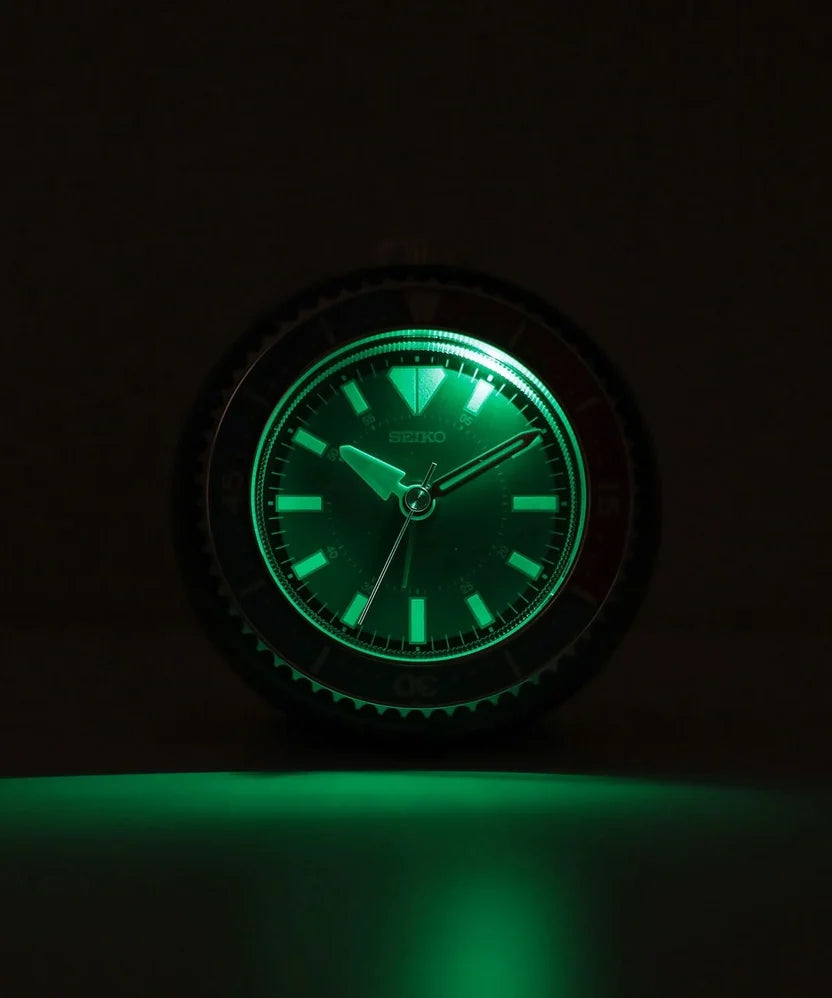 SEIKO QHE207KLH alarm clock in the dark with glowing hands and hour markers for improved nighttime visibility.