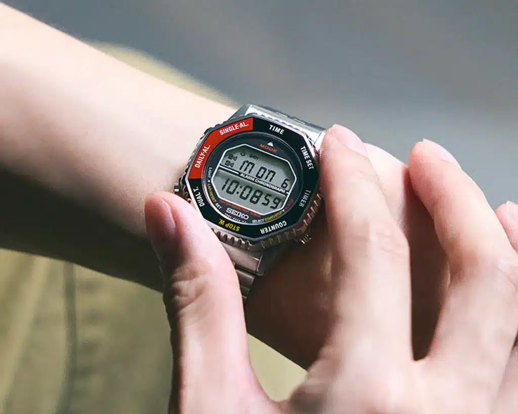 Digital wristwatch on a person's wrist with a blurred background