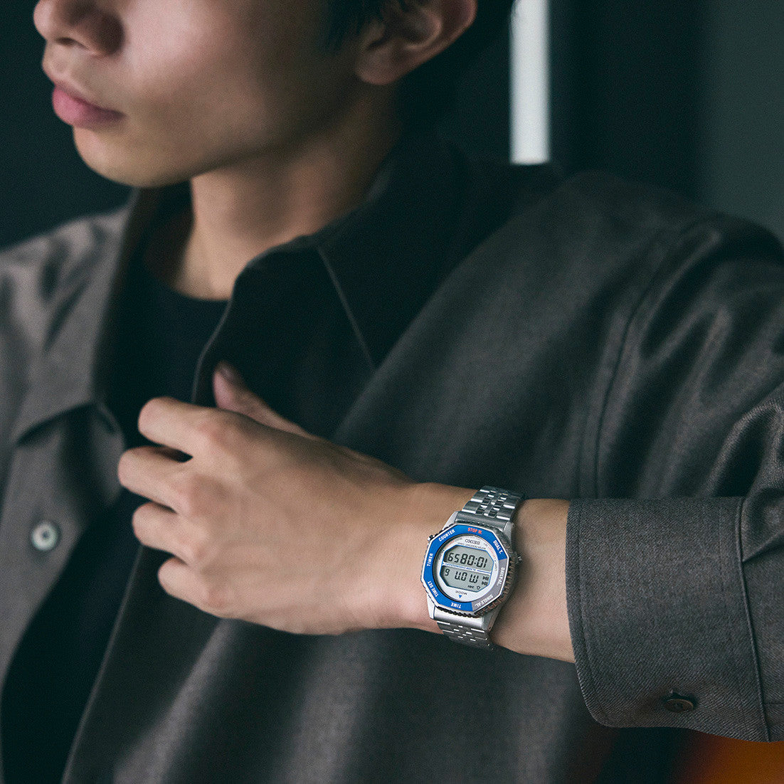 Person wearing a digital wristwatch with a dark shirt