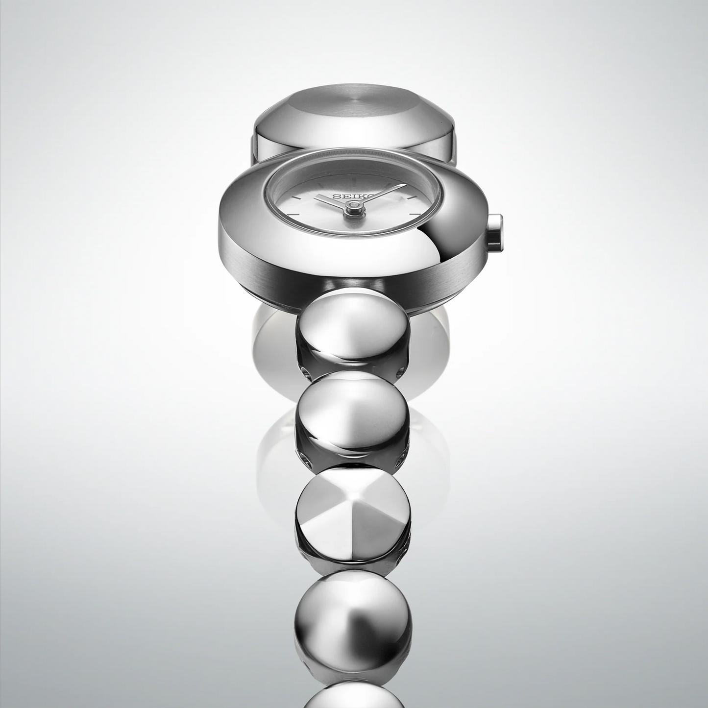 Silver watch with a unique design on a light gray background