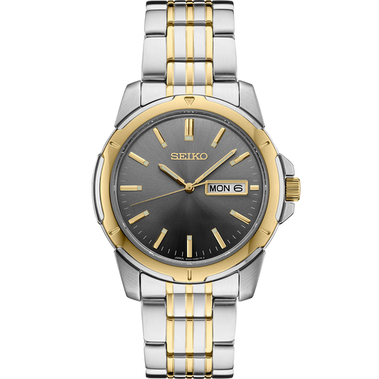 Seiko Essentials SUR356 quartz watch with gray sunray dial, gold accents, two-tone stainless steel case and bracelet, day-date display, LumiBrite hands and markers, and 100m water resistance.