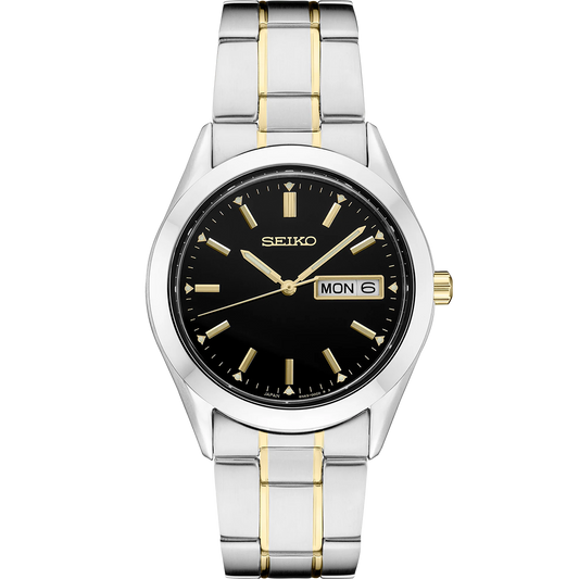 Seiko Essentials Collection SUR363 quartz watch with black dial and gold accents, day/date display, LumiBrite hands and markers, two-tone stainless steel bracelet, and classic dress-sport design with 100-meter water resistance.
