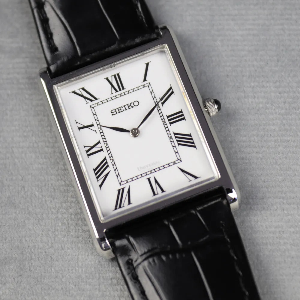Seiko watch with black leather strap on a gray background