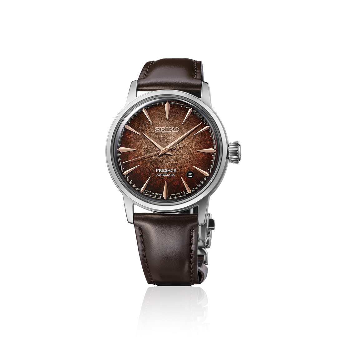 A Seiko wristwatch with a brown textured dial, rose gold-tone indices and hands, and a dark brown leather strap, shown on a clean white background with a subtle reflection.