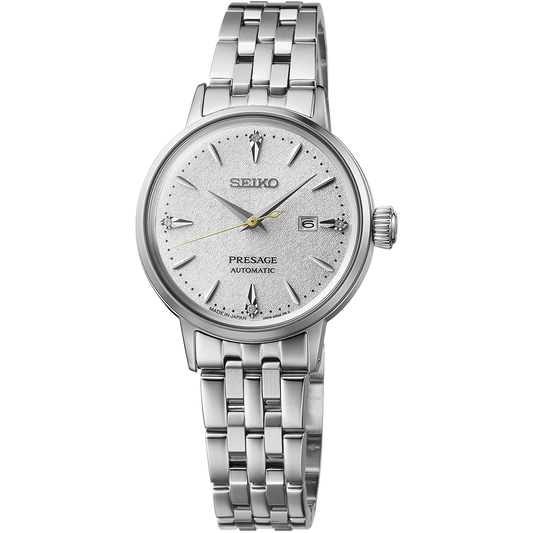 Seiko Presage Cocktail Time SRE017 women’s automatic watch featuring a 30.1 mm stainless steel case, white pressed-pattern dial inspired by the Hot Buttered Rum cocktail, and four diamond hour markers. Includes gold-tone second hand, box-shaped Hardlex crystal, and stainless steel bracelet with deployment clasp. Powered by Caliber 2R05 automatic movement with 21 jewels, 40-hour power reserve, and manual winding. Water resistant to 50 meters (5 bar).
