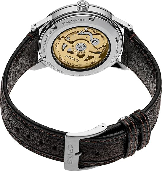 Seiko watch with brown leather strap and visible mechanical components on a white background