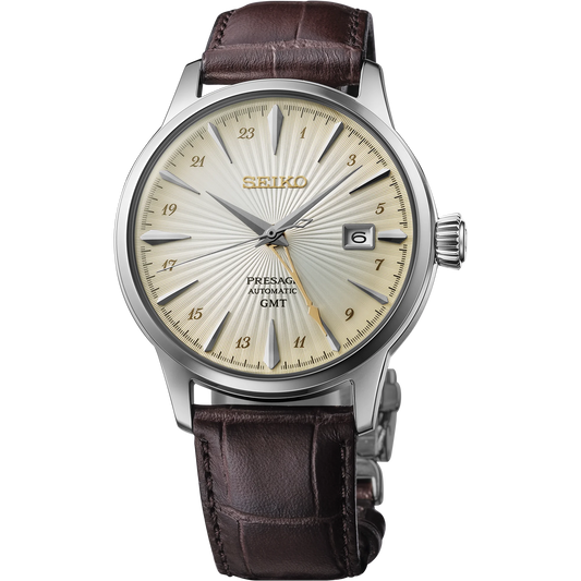 Seiko SSK041 – Presage Cocktail Time GMT watch with ivory patterned dial, gold-tone cocktail-glass-shaped GMT hand, see-through caseback, and brown leather strap; inspired by the Acacia cocktail.