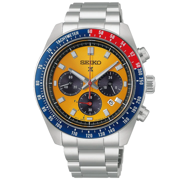 A Seiko stainless steel chronograph watch with a bright yellow dial, a blue and red tachymeter bezel, and a silver metal link bracelet, shown against a plain white background.