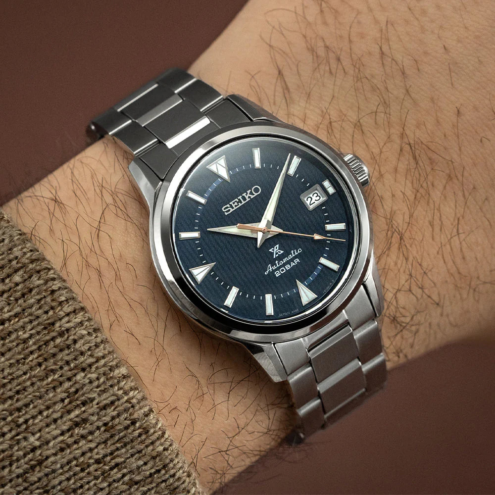 SEIKO Prospex SPB249 Alpinist – blue patterned dial with mountain-shaped markers, stainless steel case and bracelet, curved sapphire crystal, automatic movement, and 200m water resistance.