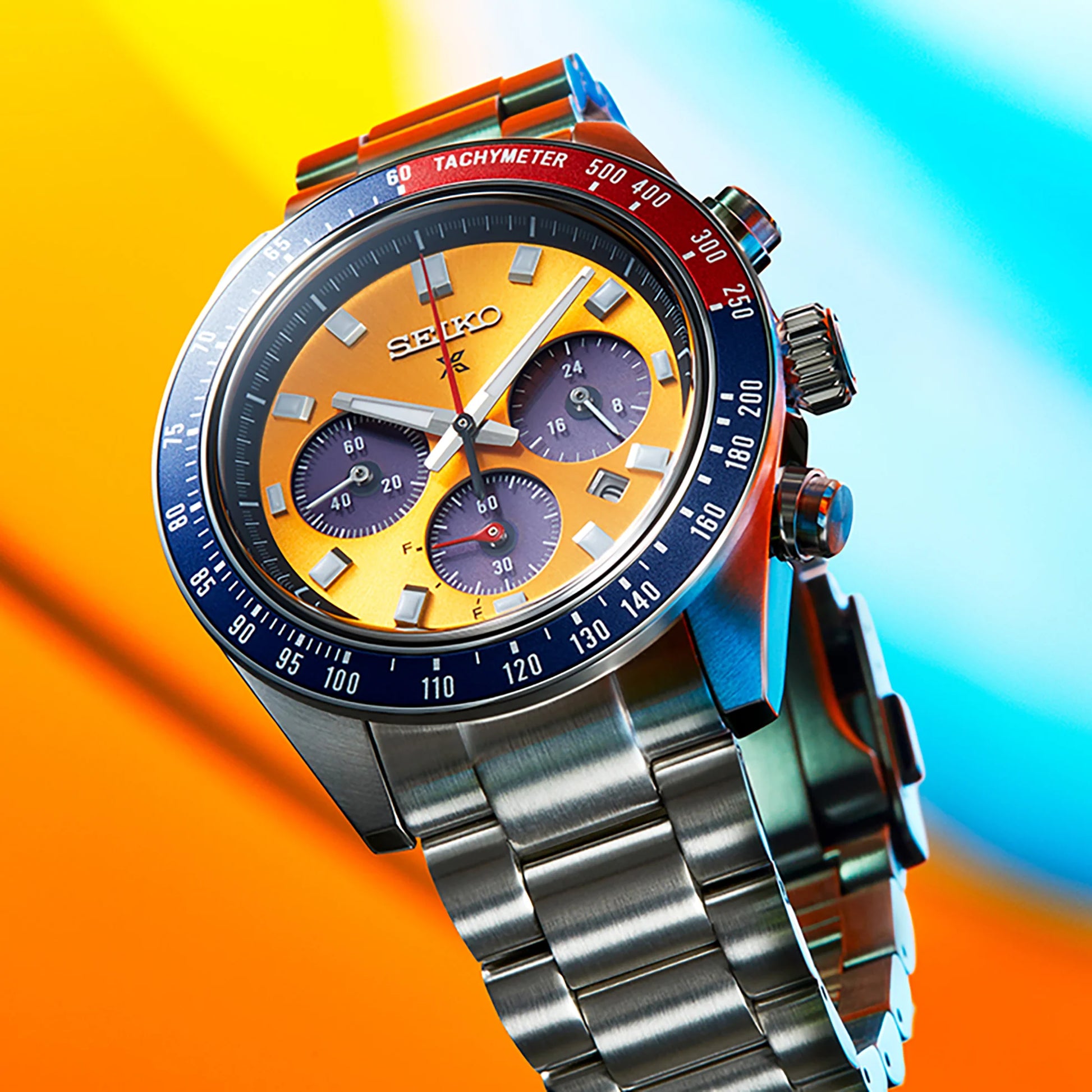 Colorful Seiko watch with a silver metal strap on a multicolored background