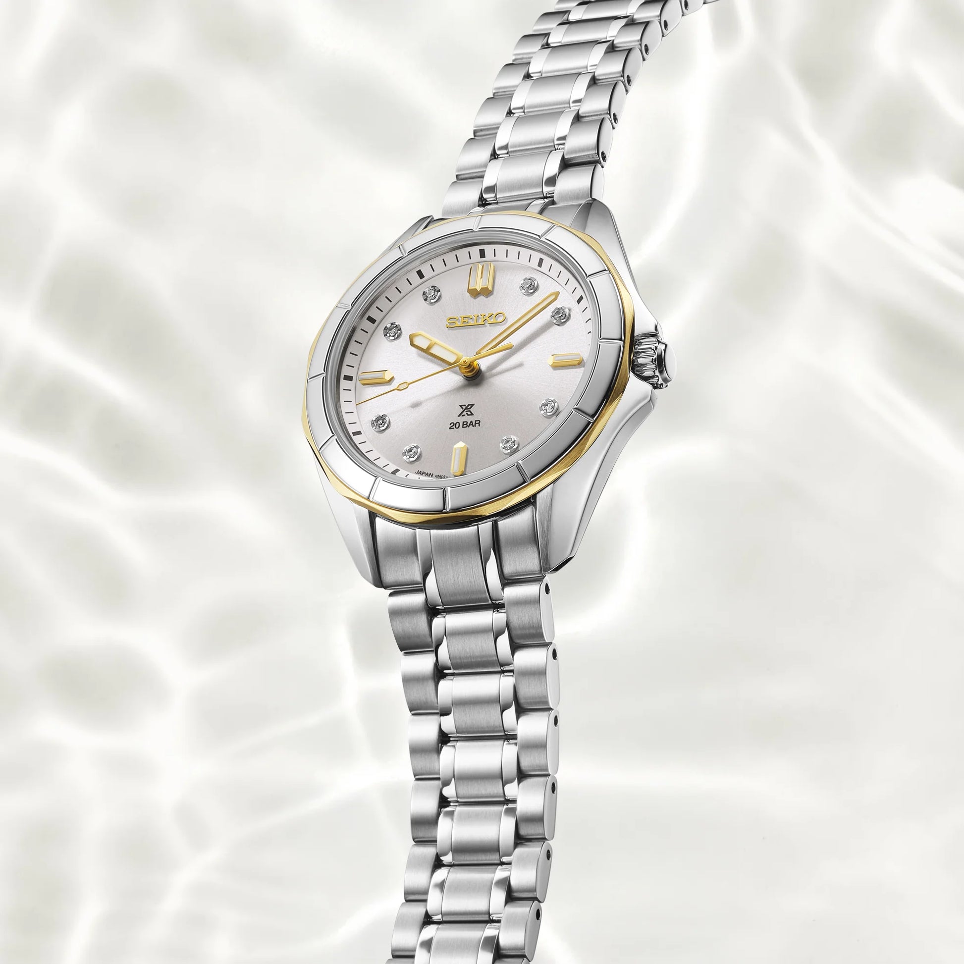 Silver Seiko watch with a white face on a white background