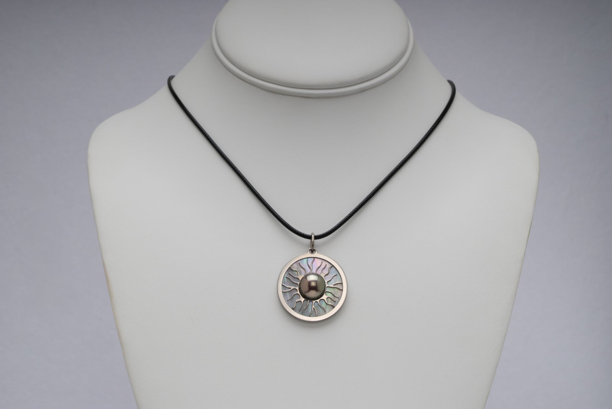 Titanium black freshwater pearl necklace with mother-of-pearl inlay, 10-11mm dyed black button-shaped pearl, exclusive sun-inspired design by Miseki Jewelry, adjustable waxed cotton cord, stainless steel lobster clasp