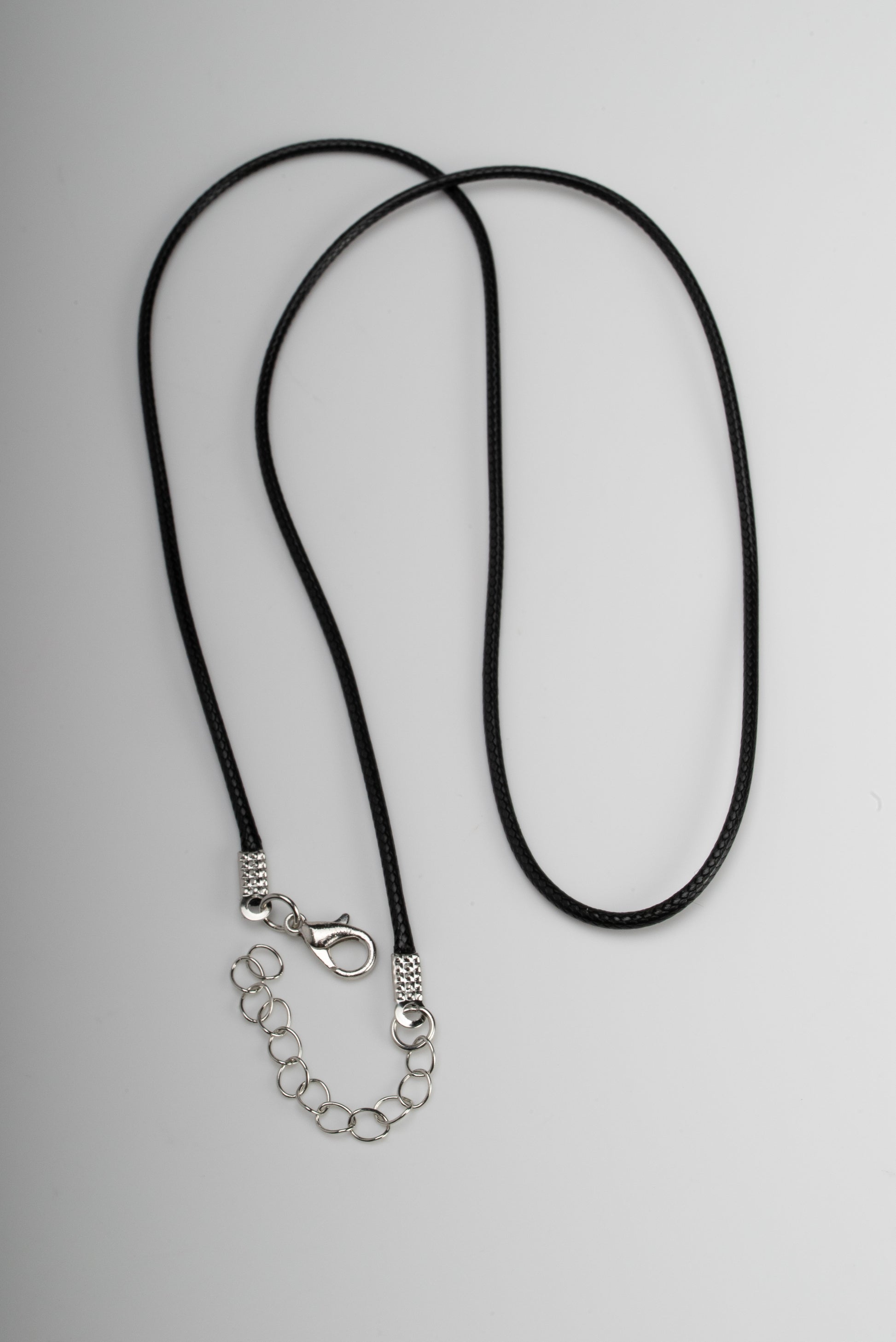 Titanium black freshwater pearl necklace with mother-of-pearl inlay, 10-11mm dyed black button-shaped pearl, exclusive sun-inspired design by Miseki Jewelry, adjustable waxed cotton cord, stainless steel lobster clasp