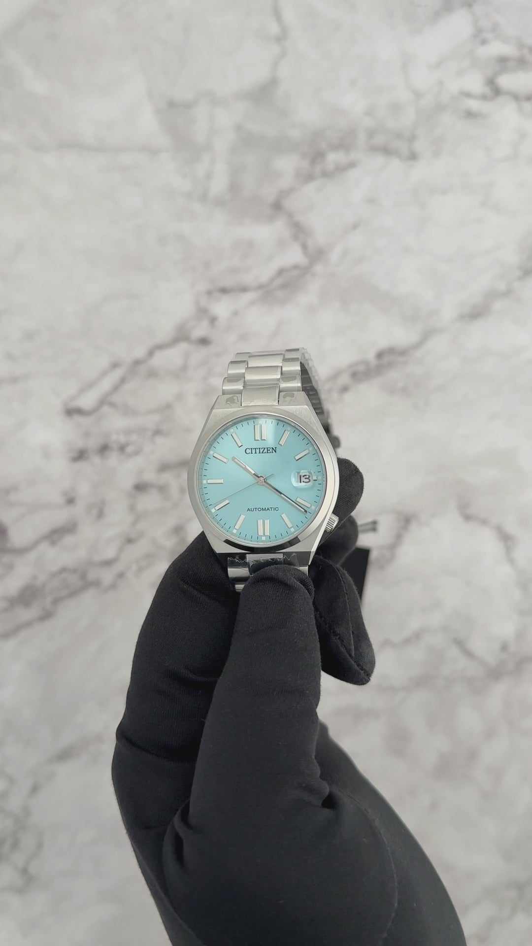 Citizen TSUYOSA NJ0200-50L – 37mm silver-tone stainless steel case, sunray ice blue dial, automatic movement, sapphire crystal, stainless steel bracelet, and 50m water resistance.