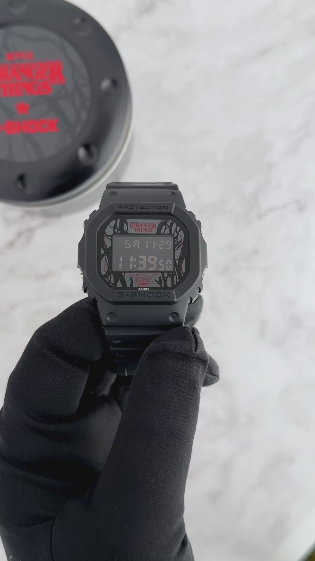 G-SHOCK DW5600STT-1 Stranger Things collaboration featuring vine-pattern dial inspired by Vecna, upside-down ‘A’ detail, red LED backlight, ‘011’ band loop tribute, bio-based black resin case and band, and special Demogorgon-themed packaging.