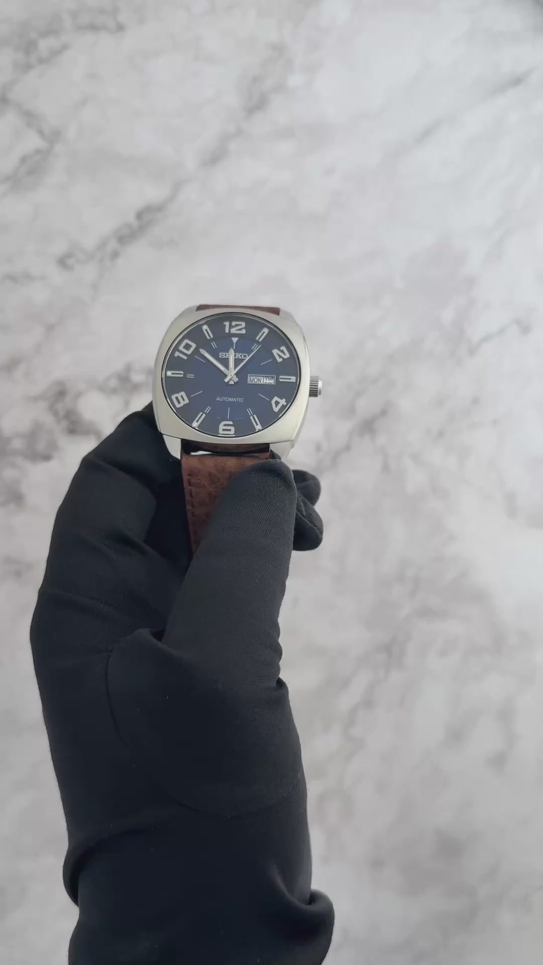 Seiko SNKN37 Recraft – bold blue dial automatic watch with retro cushion-shaped case, brown leather strap, luminous markers, see-through caseback, and 41-hour power reserve.