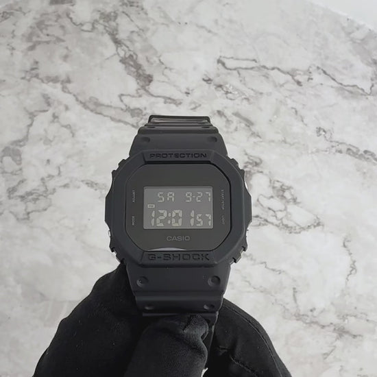 Casio G-Shock DW5600BB-1 matte black digital watch with square face, 200-meter water resistance, and electro-luminescent backlight in blackout design