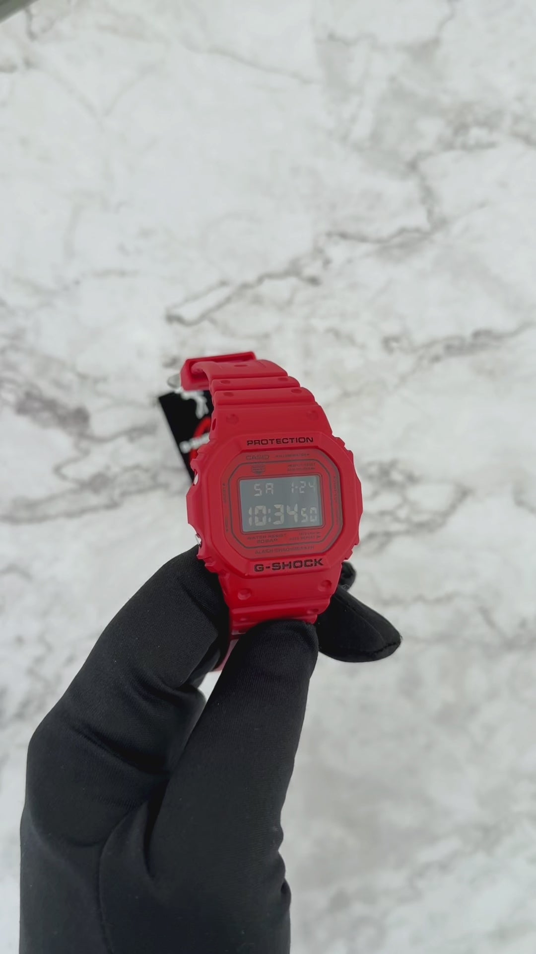 Casio G-SHOCK DW5600RRB-4 digital watch with a bold red resin case and band, black inverted LCD display, classic square 5600 design, shock-resistant construction, and 200-meter water resistance.