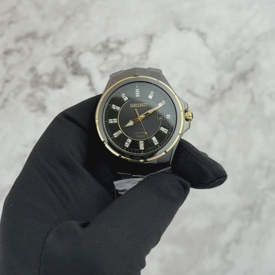 Seiko Coutura SNE506 men’s solar watch with black ion-plated stainless steel case, gold accents, black sunray dial with 15 diamond markers, and black stainless steel bracelet.