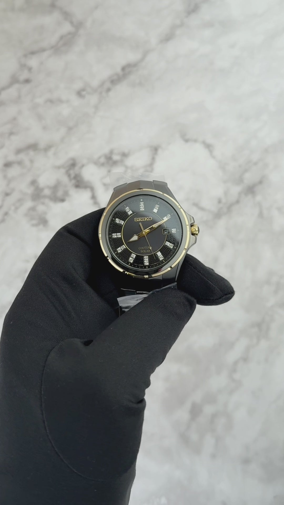 Seiko Coutura SNE506 men’s solar watch with black ion-plated stainless steel case, gold accents, black sunray dial with 15 diamond markers, and black stainless steel bracelet.